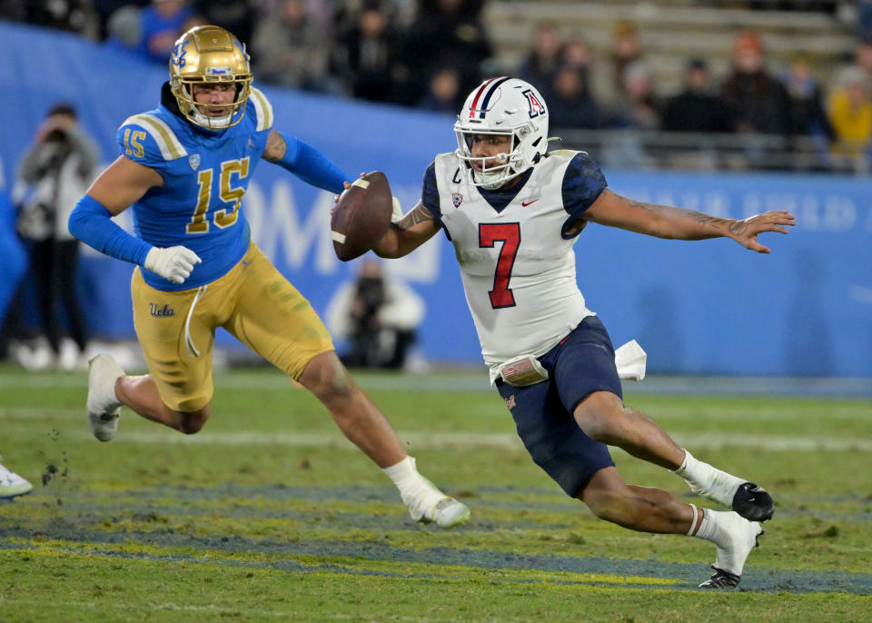 Nov 12, 2022; Pasadena, California, USA; Arizona Wildcats quarterback <a class="link " href="https://sports.yahoo.com/ncaaf/players/318866" data-i13n="sec:content-canvas;subsec:anchor_text;elm:context_link" data-ylk="slk:Jayden de Laura;sec:content-canvas;subsec:anchor_text;elm:context_link;itc:0">Jayden de Laura</a> (7) scrambles away from UCLA Bruins linebacker Laiatu Latu (15) for a 1 yard gain in the second half at the Rose Bowl. Mandatory Credit: Jayne Kamin-Oncea-USA TODAY Sports