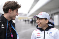 Ayumu Iwasa of Japan, reserve driver of RB, the team previously known as AlphaTauri at right talks to a team member from Alpine before the second free practice session at the Suzuka Circuit in Suzuka, central Japan, Friday, April 5, 2024, ahead of Sunday's Japanese Formula One Grand Prix. (AP Photo/Hiro Komae)