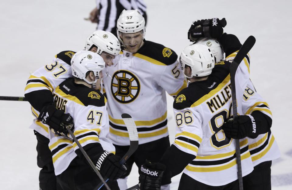 Boston Bruins, clockwise from foreground left, Torey Krug (47), Patrice Bergeron, Justin Florek, Reilly Smith and Kevan Miller (86) celebrate Krug's goal during the second period of Game 4 of a first-round NHL hockey playoff series against the Detroit Red Wings in Detroit, Thursday, April 24, 2014. (AP Photo/Carlos Osorio)