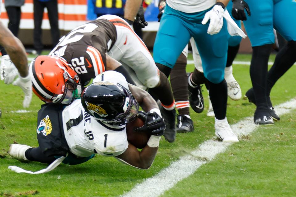 Jacksonville Jaguars running back Travis Etienne Jr. (1), defended by Cleveland Browns safety Grant Delpit (22), stretches for the endzone and the touchdown during the second half of an NFL football game, Sunday, Dec. 10, 2023, in Cleveland. (AP Photo/Ron Schwane)