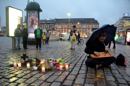 A woman plays a traditional Finnish string instrument, kantele, at the Market Square where several people were stabbed, in Turku, Finland August 18, 2017. REUTERS/Tuomas Forsell