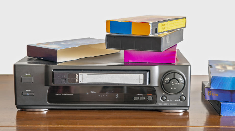 a vcr with VCR tapes on top
