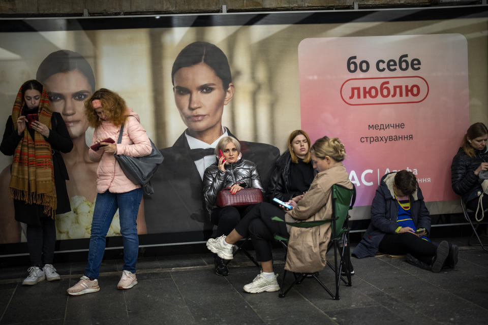 People sit in the Kyiv subway, using it as a bomb shelter, Ukraine, on Wednesday, Oct. 19, 2022. (AP Photo/Emilio Morenatti)