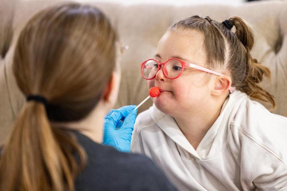 Speech therapist Leanna Vollintine gives Nora Cerda, 7, a lollipop during an exercise on Jan. 23. Vollintine, along with other speech language pathologists, campaigned to get Blue Cross Blue Shield of Texas to reverse rate cuts for speech language pathology services.