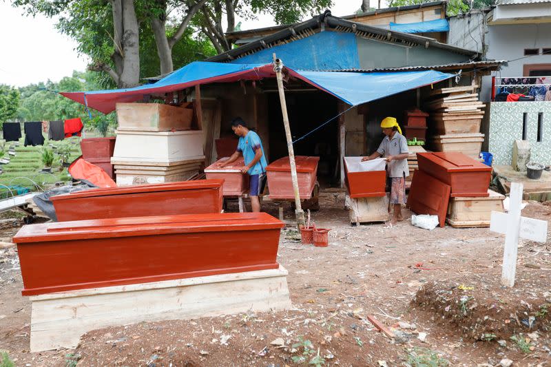 Coffin makers Ari Rusmawan, 32-year-old, and Suherman, 45-year-old, prepare coffins ordered to be donated for the coronavirus disease (COVID-19) victims at a workshop inside a funeral complex in Jakarta