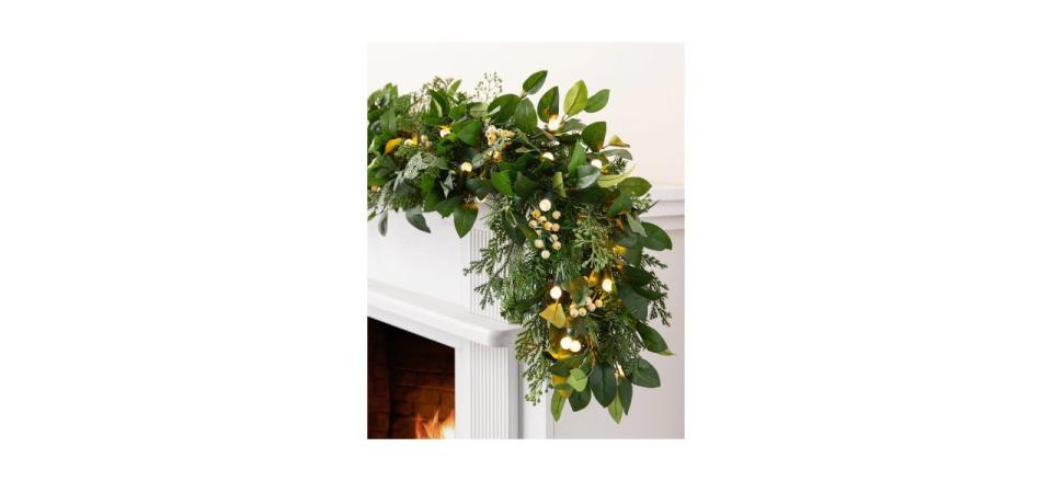 Balsam Hill White Berry Cypress Foliage 6-Foot Garland hanging up over a doorway