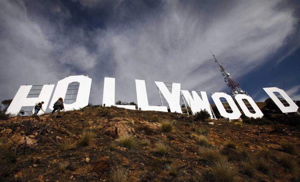 Journalists walk around the Hollywood Sign following after a 2012 refurbishment that took nine weeks to complete. This year, as part of its 100th birthday, the sign will be repainted.