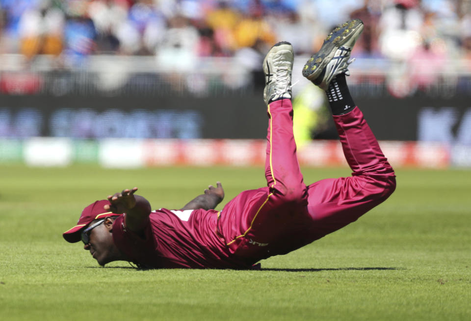 West Indies' Carlos Brathwaite dives in an unsuccessful attempt to save a boundary hit by India's K.L. Rahul during the Cricket World Cup match between India and West Indies at Old Trafford in Manchester, England, Thursday, June 27, 2019. (AP Photo/Aijaz Rahi)