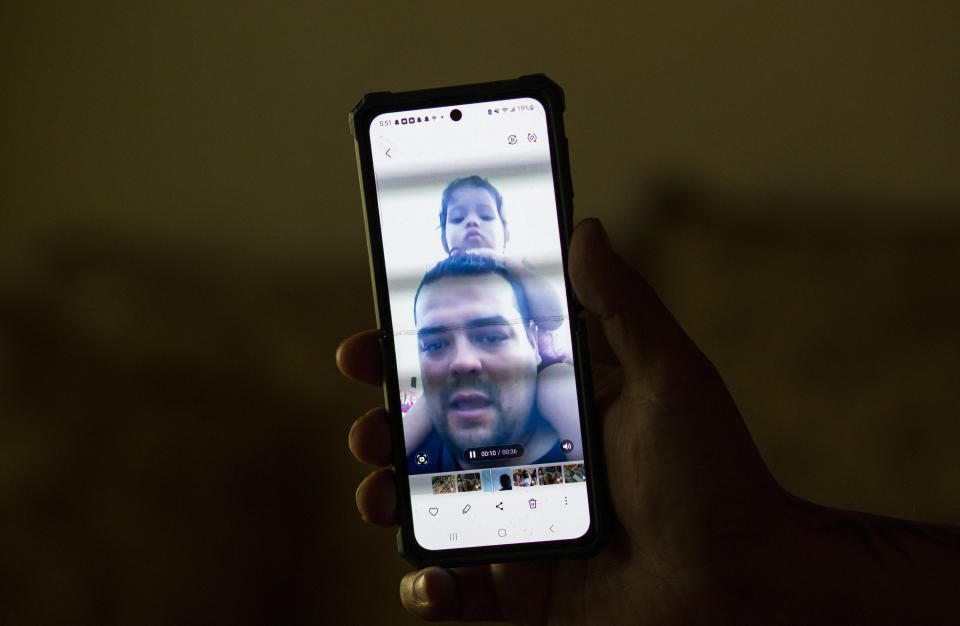 Venezuelan asylum-seeker Luis Lopez shows a video of himself and his daughter Amaloha crossing Panama's Darien Gap, during an interview with The Associated Press, in El Paso, Texas, Friday, May 12, 2023. When Lopez was lost in the Gap last year with his pregnant wife, their two children and her grandmother, he often knelt in the mud to beg God not to abandon them. (AP Photo/Andres Leighton)