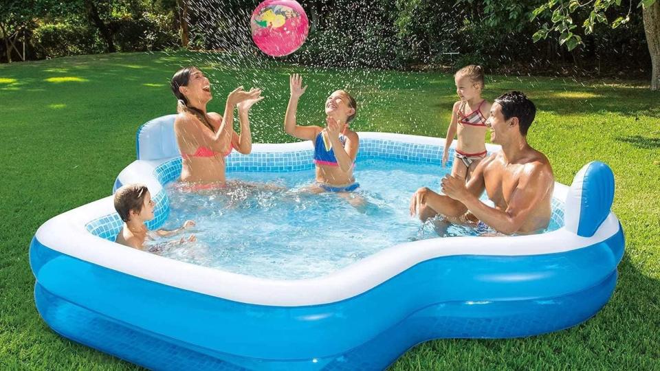 Family of five playing in the inflatable pool. 