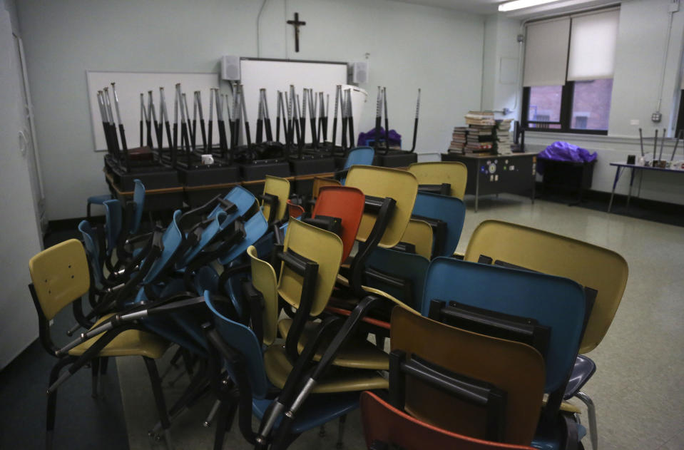 Desks are stacked in an empty classroom after the permanent closure of Queen of the Rosary Catholic Academy in Brooklyn borough of New York, Thursday, Aug. 6, 2020. (AP Photo/Jessie Wardarski)