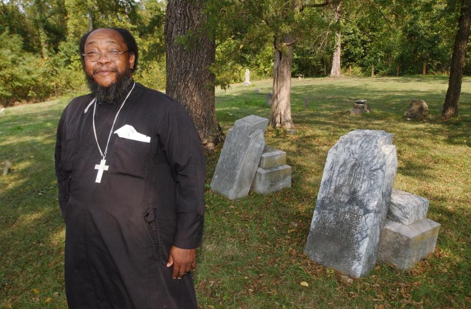 Father Moses Berry stands near the graves of his great grandparents Caroline "Boone" Berry and William Berry at the slave cemetary in Ash Grove. The cemetary is being dedicated to the National Historic Register Saturday, in part because of Berry's ancestors.