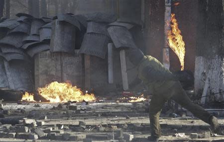 A protester throws a petrol bomb towards Interior ministry members during clashes in Kiev February 18, 2014. REUTERS/Konstantin Chernichkin