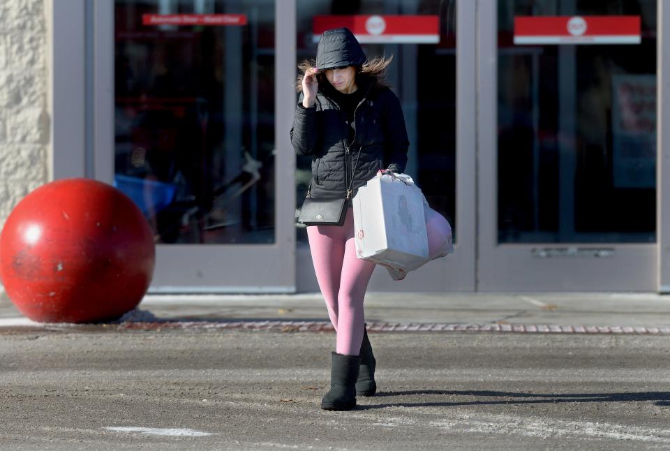 Tina Troutman of Springfield braves the cold and wind as she leaves the Target store in Parkway Plaza after getting some last minute Christmas shopping in Saturday Dec. 24, 2022.