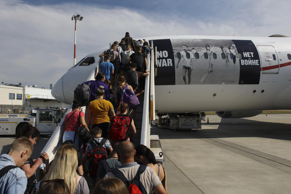 Refugiados ucranianos suben a un avión con rumbo a Canadá el lunes 4 de julio de 2022, en el aeropuerto Frederic Chopin en Varsovia, Polonia. (AP Foto/Michal Dyjuk)