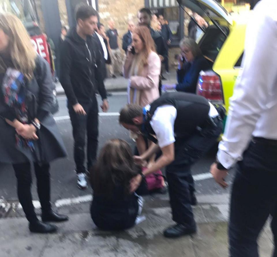 Police with a woman after the incident at Parsons Green (Metro)