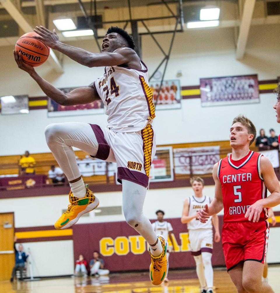 Bloomington North's JaQualon Roberts (24) soars past Center Grove's Ethan McComb (5) during the Bloomington North versus Center Grove boys basketball game at Bloomington High School North on Friday, Dec. 2, 2022.