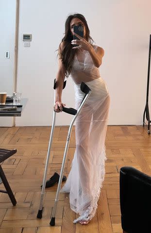 <p>Victoria Beckham/Instagram</p> Victoria Beckham posts photo on Instagram wearing white, sheer gown and using crutches.