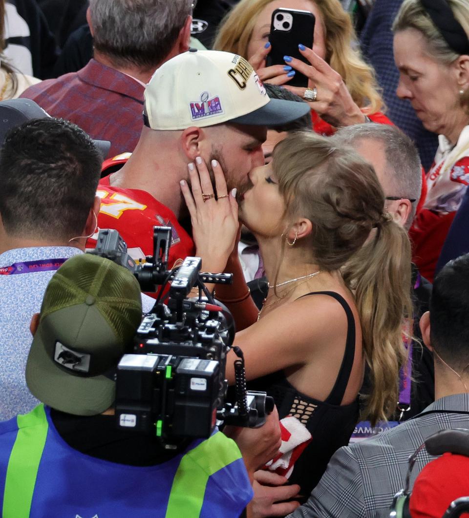 Travis and Taylor kissing after a Chiefs game