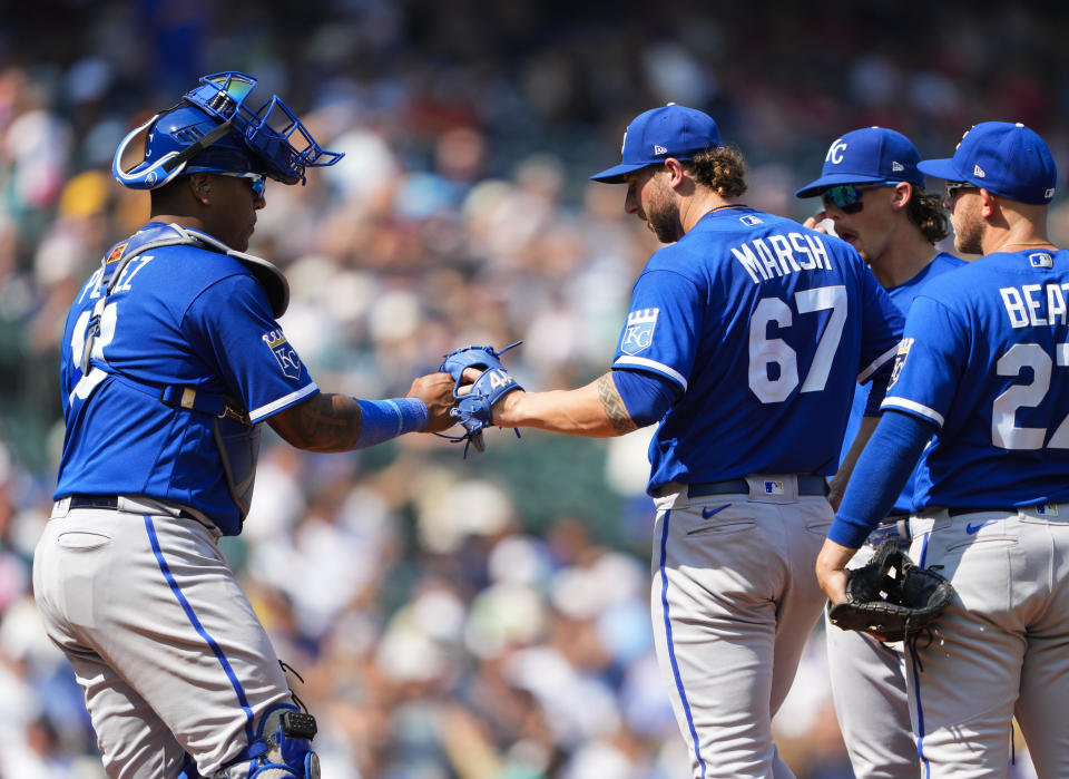 Kansas City Royals catcher Salvador Perez, left, greets starting pitcher Alec Marsh as he is relieved against the Seattle Mariners during the sixth inning of a baseball game, Sunday, Aug. 27, 2023, in Seattle. (AP Photo/Lindsey Wasson)