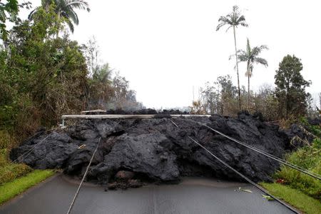 Lava and downed power lines block a road in the Leilani Estates subdivision during ongoing eruptions of the Kilauea Volcano, Hawaii, U.S., May 8, 2018. REUTERS/Terray Sylvester