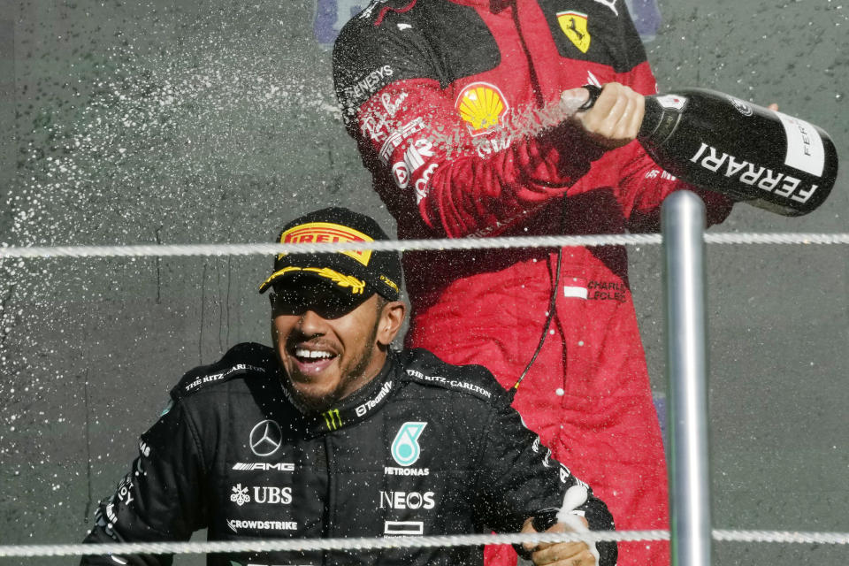 FILE - second placed Mercedes driver Lewis Hamilton of Britain, bottom, is sprayed with champagne by third placed Ferrari driver Charles Leclerc of Monaco on the podium for the Formula One Mexico Grand Prix auto race at the Hermanos Rodriguez racetrack in Mexico City, Sunday, Oct. 29, 2023. Seven-time Formula One champion Lewis Hamilton has been linked with a shock move from Mercedes to Ferrari next year. (AP Photo/Fernando Llano, File)