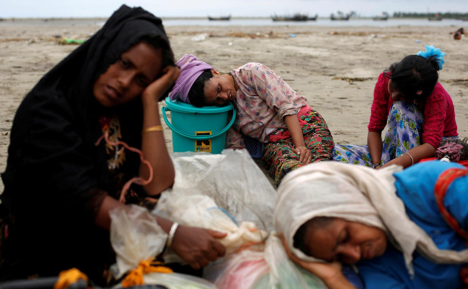 Exhausted Rohingya refugees rest on the shore after crossing the Bangladesh-Myanmar border by boat through the Bay of Bengal in Shah Porir Dwip, Bangladesh, on Sept. 10, 2017.