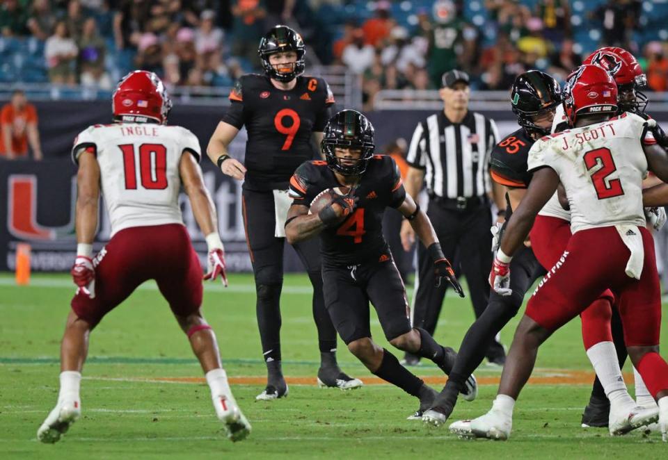 Miami Hurricanes quarterback Tyler Van Dyke (9) hand off to Hurricanes running back Jaylan Knighton (4) during the fourth quarter of their ACC football game against the North Carolina State Wolfpack at Hard Rock Stadium on Saturday, October 23, 2021 in Miami Gardens, Florida.