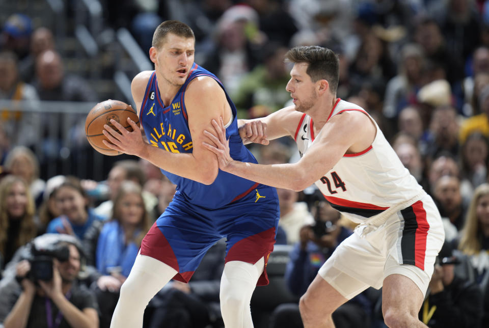 Denver Nuggets center Nikola Jokic, left, looks to drive to the rim as Portland Trail Blazers forward Drew Eubanks defends in the first half of an NBA basketball game Friday, Dec. 23, 2022, in Denver. (AP Photo/David Zalubowski)