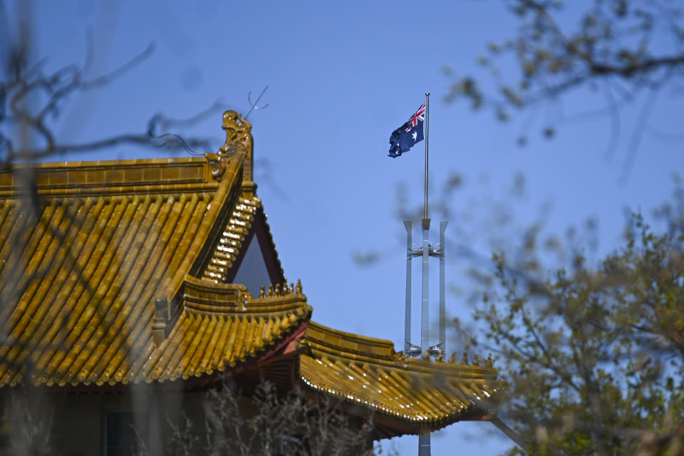 The flag pole of the Australian Parliament is seen behind the roof of the Chinese Embassy in Canberra, Friday, September 17, 2021. 