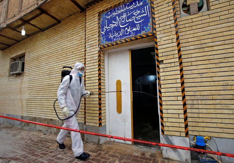 A member of the medical team sprays disinfectant to sanitize the area near a religious school where the?first?coronavirus?case?was detected, following the outbreak of the new?coronavirus, in the holy city of Najaf