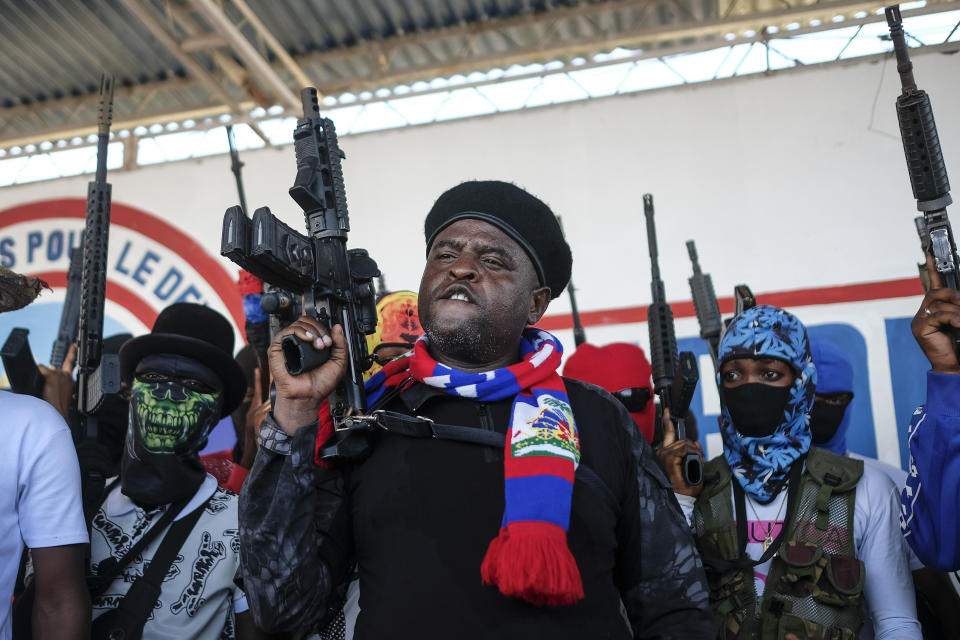 FILE - Barbecue, the leader of the "G9 and Family" gang, shouts slogans with his gang members after giving a speech, as he leads a march against kidnapping through La Saline neighborhood in Port-au-Prince, Haiti, Oct. 22, 2021. Barbecue, a former policeman, fancies himself a man of the people and an enemy of the elite. (AP Photo/Matias Delacroix, File)