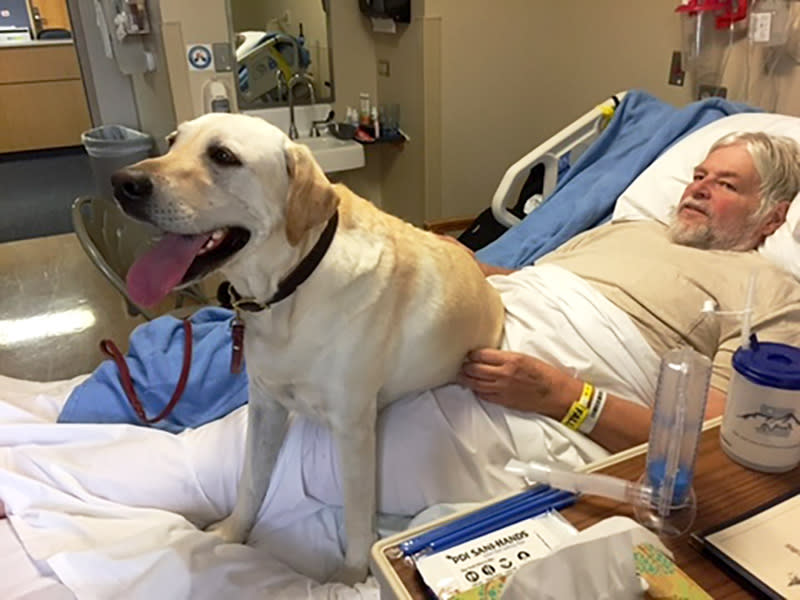 John VanDenBerg lies in bed paralyzed, with his dog, in Sept. 2018. (Courtesy John VanDenBerg)