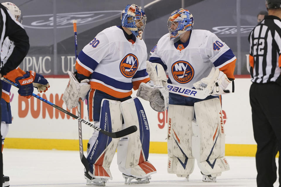 New York Islanders goaltender Semyon Varlamov (40) talks with goaltender Ilya Sorokin (30) as Varlamov replaces Sorokin during the second period of an NHL hockey game against the Pittsburgh Penguins, Saturday, March 27, 2021, in Pittsburgh. The Penguins had scored four goals on Sorokin. (AP Photo/Keith Srakocic)