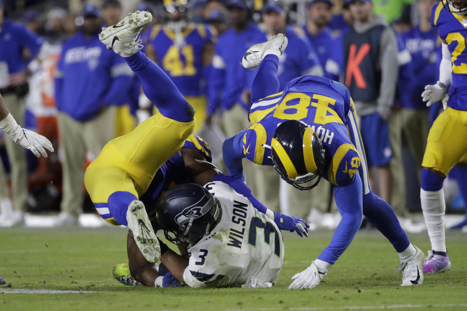 El quarterback de los Seahawks de Seattle Russell Wilson es capturado por el linebacker de los Rams de Los Ángeles Obo Okoronkwo y el linebacker Travin Howard, en la segunda mitad del juego del domingo 8 de diciembre de 2019, en Los Ángeles. (AP Foto/Marcio Jose Sanchez)