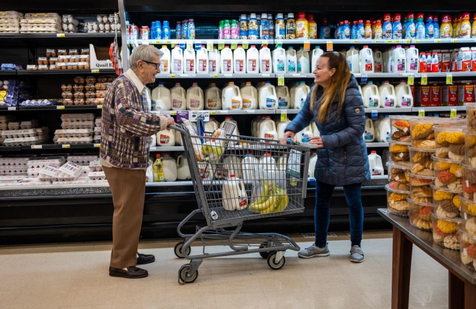 Steve Hideg, 91, left, shops with his caregiver Helen Major, right, at Jons International Market in Los Angeles.