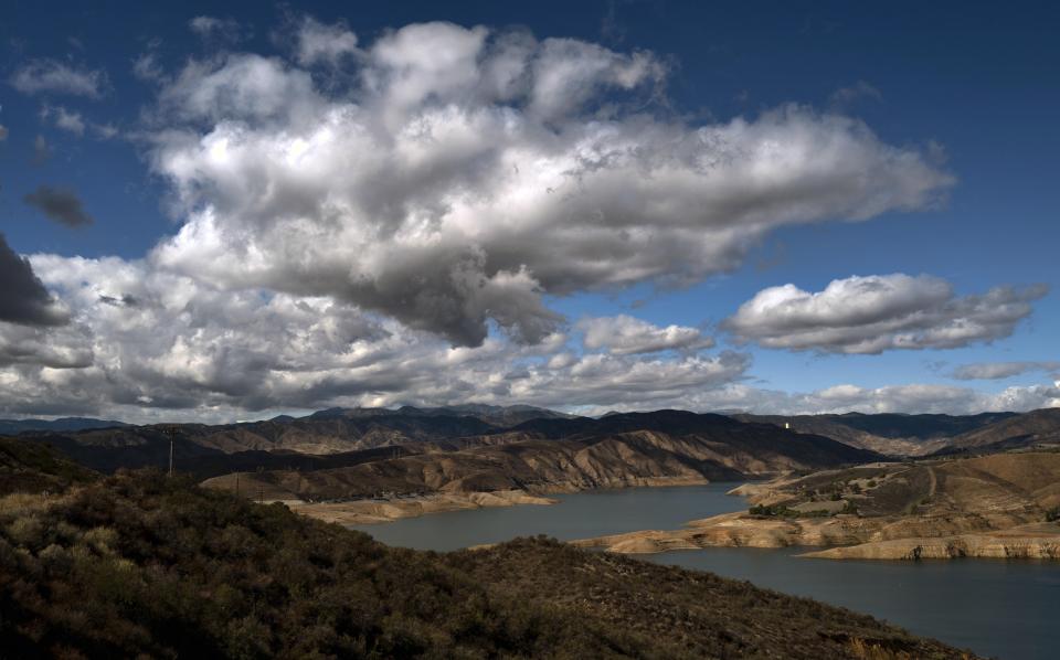 Passing storm clouds move over Castaic Lake in Castaic, Calif. on Wednesday, Nov. 9, 2022. A powerful storm pounded California with rain and snow Tuesday, leaving one person dead and two others missing after they were swept away by floodwaters in a canal, while a tornado touched down in Sacramento County. (AP Photo/Richard Vogel)