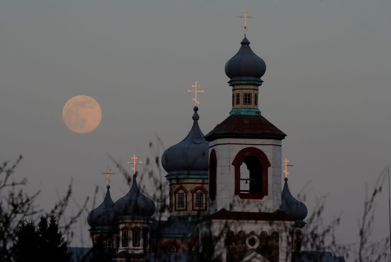 A Pink Supermoon rises behind an Orthodox Church in the village of Turets