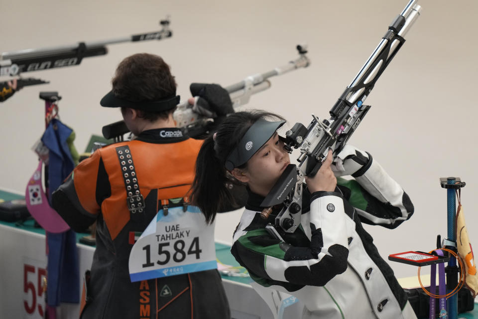 China's Jiayu Han, right, pauses as she competes in the women's 10-meter air rifle qualification at the Fuyang Yinhu Sports Centre in the 19th Asian Games in Hangzhou, China, Sunday, Sept. 24, 2023. (AP Photo/Aijaz Rahi)