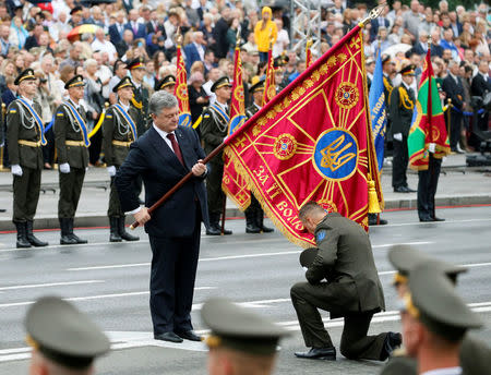 Ukrainian President Petro Poroshenko holds a flag as he takes part in Ukraine's Independence Day military parade in central Kiev, Ukraine, August 24, 2016. REUTERS/Gleb Garanich