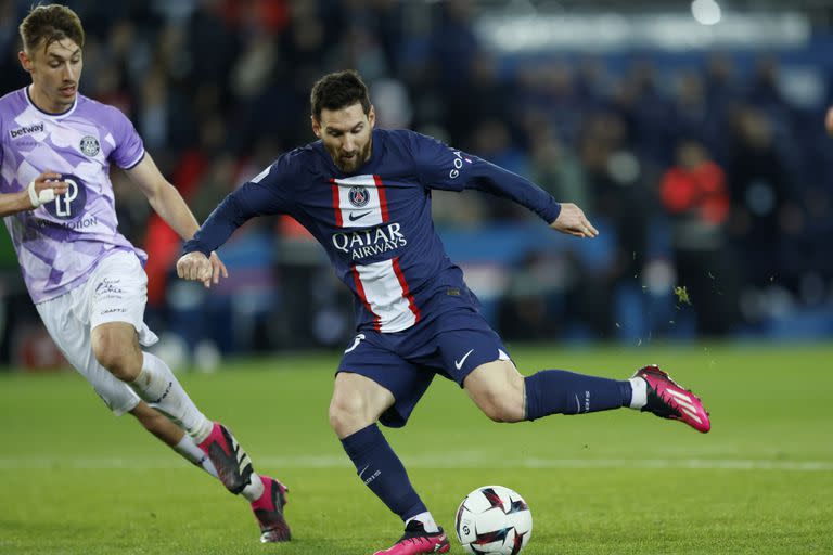 Lionel Messi del Paris Saint-Germain patea el balón mientras lo defiende Anthony Rouault del Toulouse en el encuentro de la liga francesa el sábado 4 de febrero del 2023. (AP Foto/Lewis Joly)