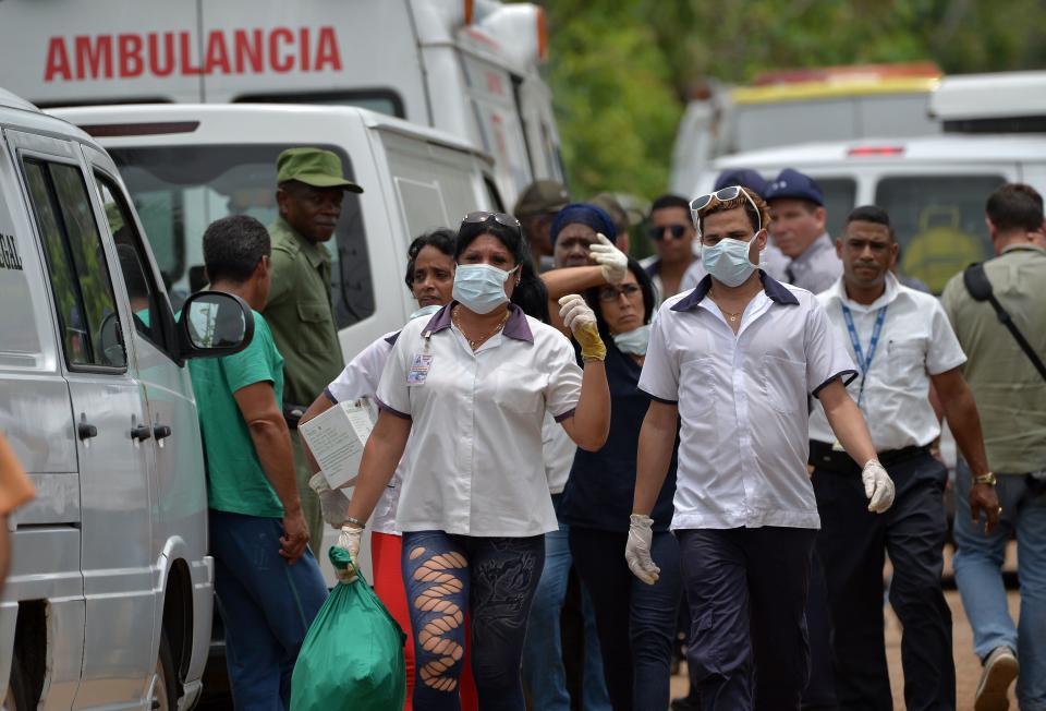 <p>Emergency personnel at seen at the site of the accident after a Cubana de Aviacion aircraft crashed after taking off from Havana’s Jose Marti airport on May 18, 2018. – A Cuban state airways passenger plane with 113 people on board crashed on shortly after taking off from Havana’s airport, state media reported. The Boeing 737 operated by Cubana de Aviacion crashed “near the international airport,” state agency Prensa Latina reported. Airport sources said the jetliner was heading from the capital to the eastern city of Holguin. (Photo: Adalberto Roque/AFP/Getty Images) </p>