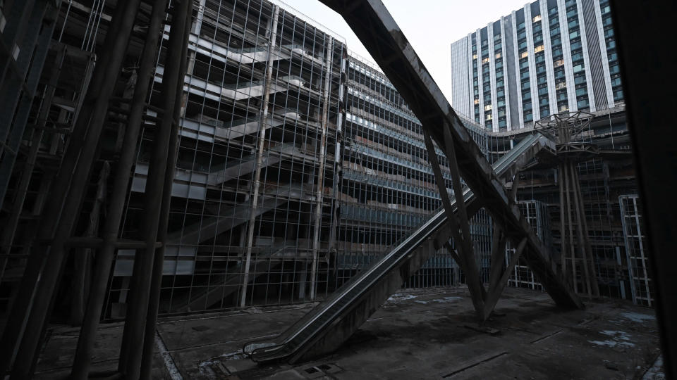 Escalators are seen in an abandoned Evergrande commercial complex in Beijing on January 29, 2024. A Hong Kong court on January 29 ordered the liquidation of China's property giant Evergrande, but the firm said it would continue to operate in a case that has become a symbol of the nation's deepening economic woes. (Photo by GREG BAKER / AFP)