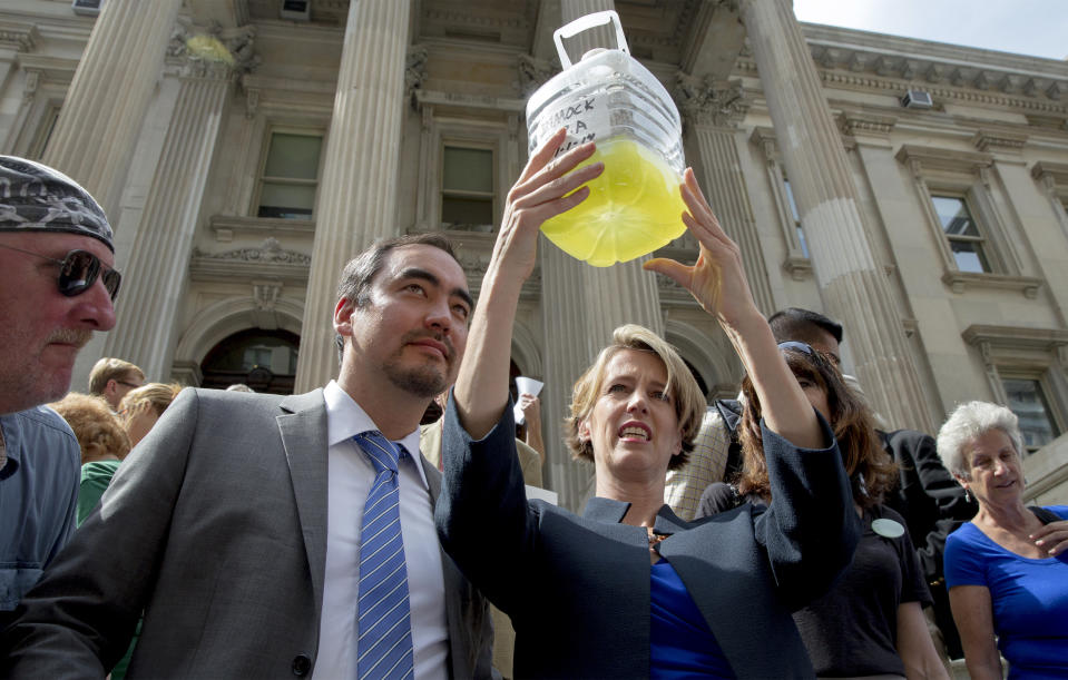 New York State democratic governor candidate Zephyr Teachout (R) holds a a bottle of frack contaminated water as lieutenant governor running mate Tim Wu (2nd L) looks on during a campaign event in New York September 3, 2014.  REUTERS/Brendan McDermid/File Photo