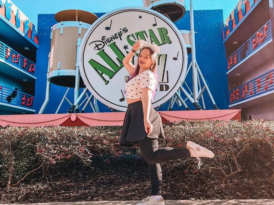 jenna posing in front of a big sign at disney's all star music resort