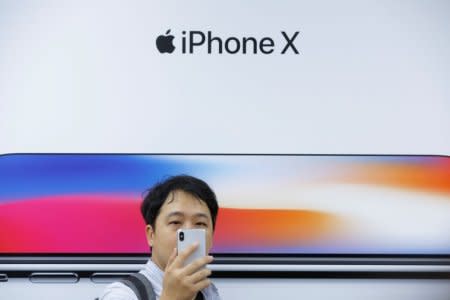 FILE PHOTO: An attendee uses a new iPhone X during a presentation for the media in Beijing, China October 31, 2017. REUTERS/Thomas Peter/File Photo