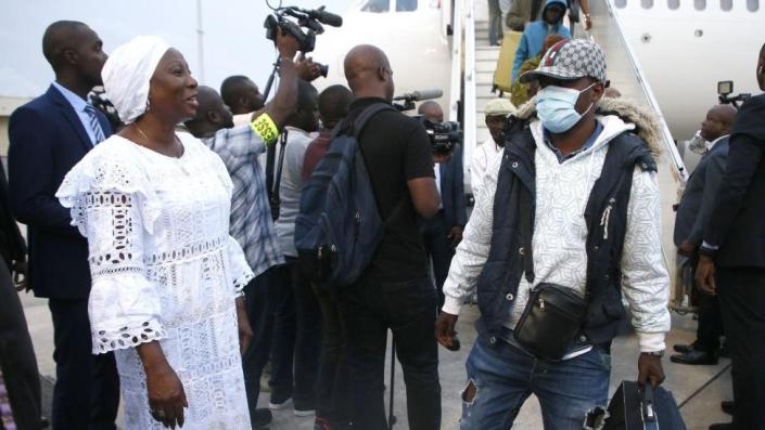 Ivorian Foreign Minister and Foreign Minister Kandia Camara (L) welcomes some of the hundreds of sub-Saharan Africans arriving from Tunisia at Abidjan Airport, Ivory Coast, on March 4
