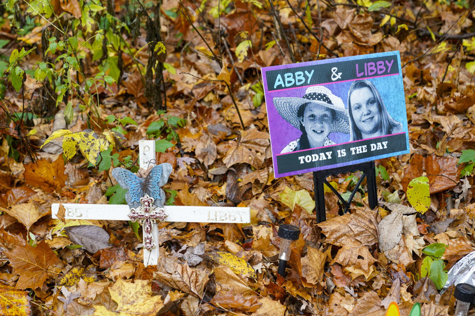 A makeshift memorial to Liberty German, and Abigail Williams near where they were last seen and where the bodies were discovered stands along the Monon Trail leading to the Monon High Bridge Trail in Delphi, Ind., Monday, Oct. 31, 2022. The Indiana State Police announced an arrest in the murders of the two teenage girls killed during a 2017 hiking trip in northern Indiana. (AP Photo/Michael Conroy)