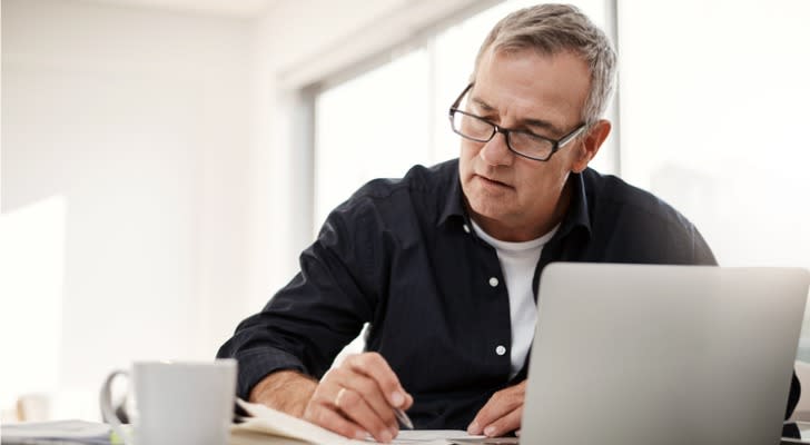 A man calculates his Social Security benefits to determine whether he should delay them or collect them early.