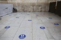 Marks to keep a 2-meter distance are seen on the floor at the Western Wall, the holiest site where Jews can pray in Jerusalem's old city, Wednesday, Sept. 16, 2020. A raging coronavirus outbreak is casting a shadow over the normally festive Jewish New Year. With health officials recommending a nationwide lockdown, traditional family gatherings will be muted, synagogue prayers will be limited to small groups and roads will be empty. (AP Photo/Sebastian Scheiner)